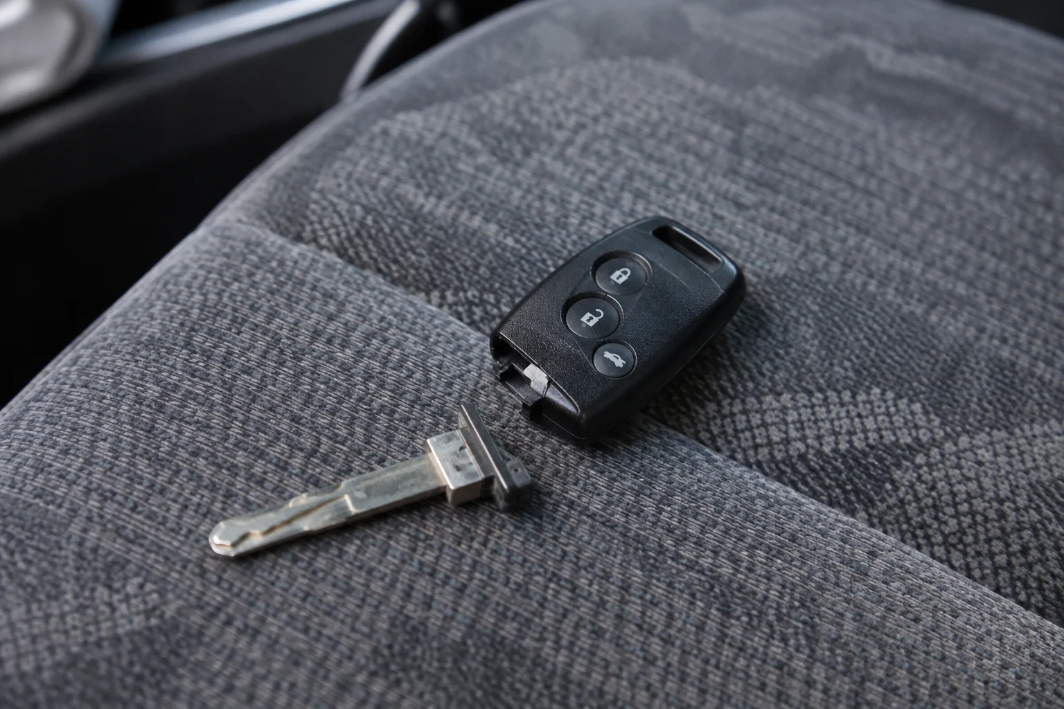 Ant audinio padėtas automobilio rakto korpusas ir nuo jo atsiskyrusi metalinė geležtė.