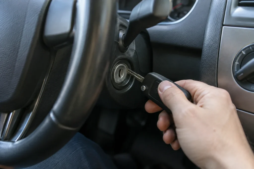 Vairuotojas laiko automobilio raktą prie užvedimo spynos.