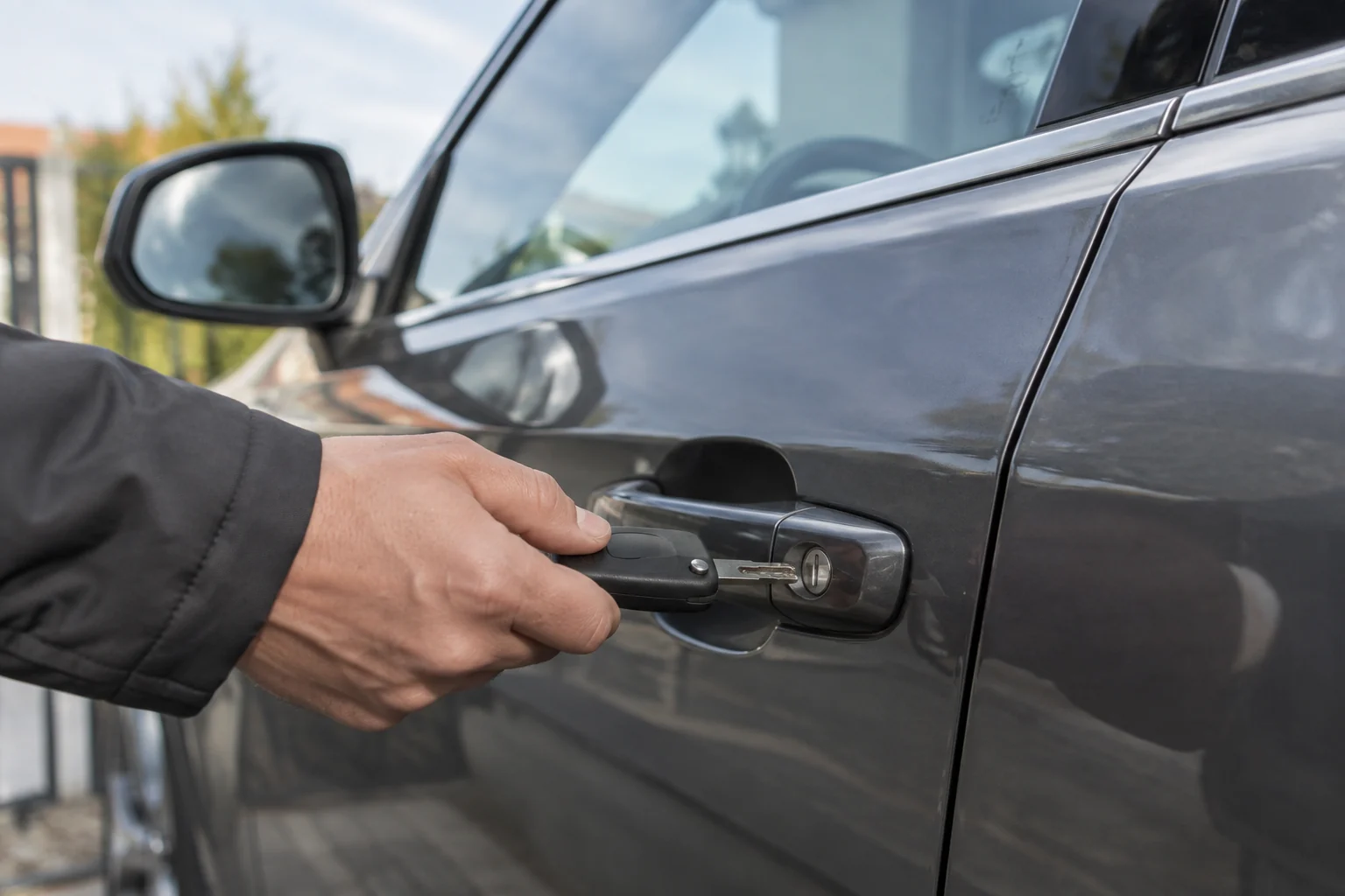Ranka įstato mechaninį automobilio raktą į durelių spynelę.